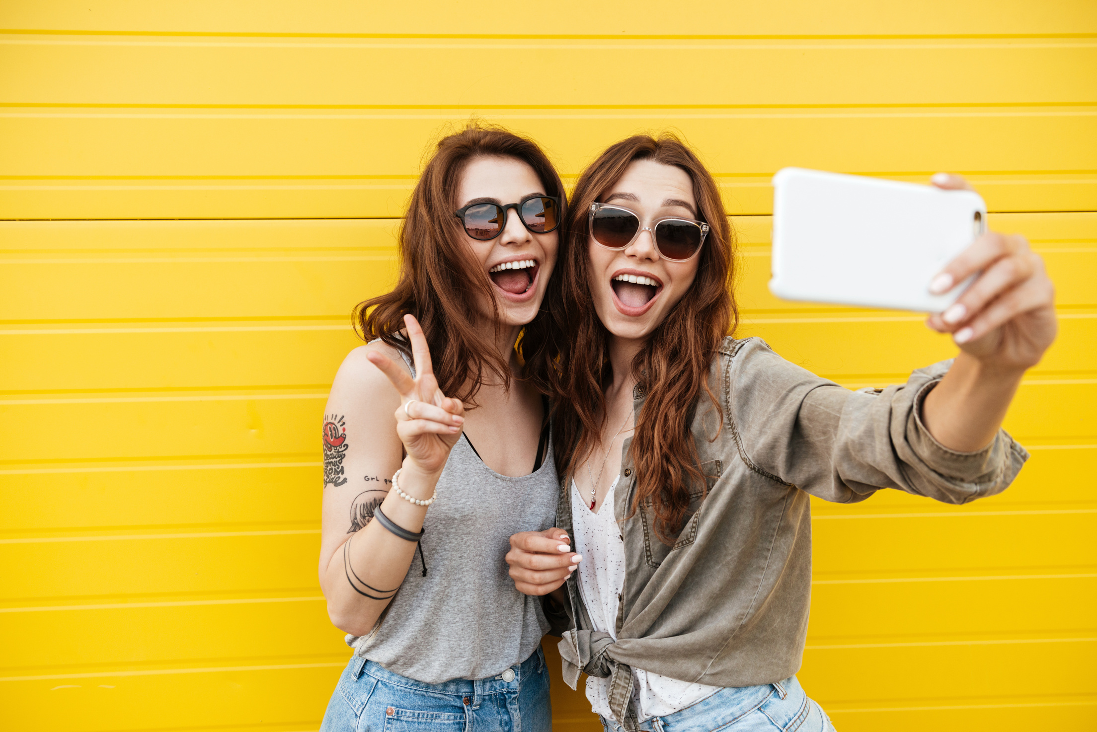 Two girl friends taking a selfie. Finding new friends for adventures is easy with Buddy Pass! 